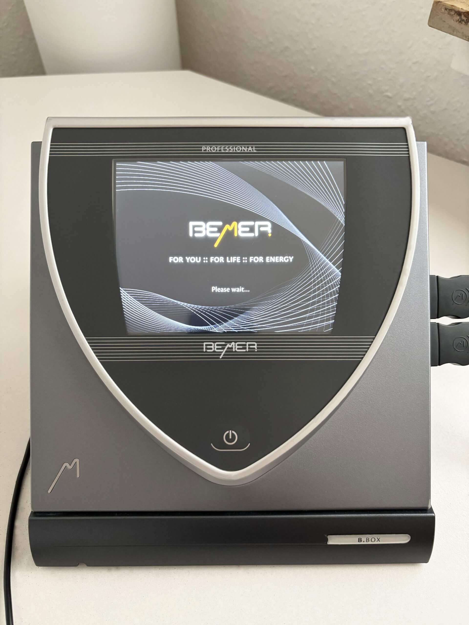 Graues BEMER B.BOX Professional Steuergerät. Das Display zeigt: BEMER FOR YOU :: FOR LIFE :: FOR ENERGY Please wait...
